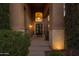 Home's entryway with double doors, lighting, and landscaping at night at 1007 W Armstrong Way, Chandler, AZ 85286