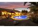 Evening view of a kidney-shaped pool with lights and landscaping at 1007 W Armstrong Way, Chandler, AZ 85286