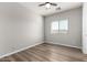 Well-lit bedroom featuring wood-look floors and window blinds at 10116 W Luxton Ln, Tolleson, AZ 85353