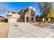 Two-story house with Spanish-style architecture, featuring a large garage and landscaped front yard at 10116 W Luxton Ln, Tolleson, AZ 85353