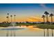 Serene lake view at sunset, with palm trees and mountains in the background at 10329 E Sunridge Dr, Sun Lakes, AZ 85248