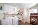 Practical laundry room with washer, dryer, and storage cabinets at 10742 W Cheryl Dr, Sun City, AZ 85351