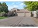 Tan two-story house with three-car garage and landscaped front yard at 12056 E Bella Vista Cir, Scottsdale, AZ 85259