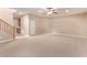 Large basement room with neutral carpeting and staircase at 12061 W Miner Trl, Peoria, AZ 85383