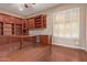 Spacious home office features built-in wooden shelves and desk at 12061 W Miner Trl, Peoria, AZ 85383