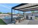 Outdoor kitchen, pool, and dining area under pergola at 12075 N 76Th Ct, Scottsdale, AZ 85260