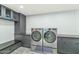 Clean laundry room with washer, dryer, and ample cabinet space at 12075 N 76Th Ct, Scottsdale, AZ 85260