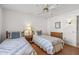 Well-lit bedroom featuring twin beds, ceiling fan, and wood flooring at 12539 W Shadow Hills Dr, Sun City West, AZ 85375