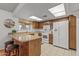 L-shaped kitchen with white appliances and wood cabinets at 12539 W Shadow Hills Dr, Sun City West, AZ 85375