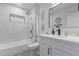 Bathroom with white vanity, bathtub, and marble tile shower surround at 13614 N Hawthorn Dr, Sun City, AZ 85351