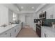 Modern kitchen with white cabinets, quartz countertops, and stainless steel appliances at 13614 N Hawthorn Dr, Sun City, AZ 85351