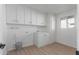 Bright laundry room with ample cabinet space and vinyl flooring at 13614 N Hawthorn Dr, Sun City, AZ 85351