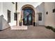 Elegant entryway with a wrought iron door and stone archway at 13648 E Aloe Vera Dr, Scottsdale, AZ 85262