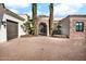 Front view of a luxurious home with stone accents and a gated entry at 13648 E Aloe Vera Dr, Scottsdale, AZ 85262