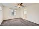 Bedroom with carpet, window blinds, ceiling fan, and access to bathroom at 14238 W Bronco Trl, Surprise, AZ 85387