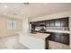 Modern kitchen featuring dark cabinetry, an island, and tile backsplash at 14238 W Bronco Trl, Surprise, AZ 85387