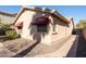 Tan house exterior with red awnings and a brick pathway at 16549 W Desert Ln, Surprise, AZ 85388