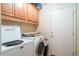 Laundry room with washer, dryer, cabinets, and access door at 16549 W Desert Ln, Surprise, AZ 85388