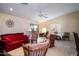 Bright living room featuring a red couch, wooden rocking chairs, and a ceiling fan at 16549 W Desert Ln, Surprise, AZ 85388