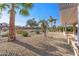 Landscaped backyard with gravel, trees, and a fence at 16935 W Villagio Dr, Surprise, AZ 85387