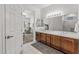 Double vanity bathroom with wood cabinets and view of bedroom at 16935 W Villagio Dr, Surprise, AZ 85387