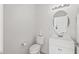 Clean bathroom with white vanity, toilet and round mirror at 16935 W Villagio Dr, Surprise, AZ 85387