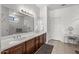 Double vanity bathroom with dark wood cabinets and large mirror at 16935 W Villagio Dr, Surprise, AZ 85387