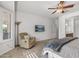 Relaxing bedroom with comfy chair, large TV, and ceiling fan at 16935 W Villagio Dr, Surprise, AZ 85387