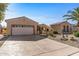 Two-car garage and desert landscaping with cactus plants at 16935 W Villagio Dr, Surprise, AZ 85387