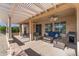 Relaxing covered patio with seating area, ceiling fan, and built-in grill at 16935 W Villagio Dr, Surprise, AZ 85387