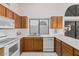 Kitchen with white appliances and wood cabinets at 19662 N 93Rd Dr, Peoria, AZ 85382