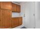 Laundry room with wood cabinets and exterior access at 19662 N 93Rd Dr, Peoria, AZ 85382