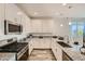 Modern kitchen with white cabinets, granite countertops and stainless steel appliances at 20886 S 231St St, Queen Creek, AZ 85142