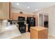 Spacious kitchen featuring wood cabinets, black appliances, and an island at 21816 N 261St Ave, Buckeye, AZ 85396