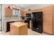 Kitchen with wood cabinets, black appliances, and an island at 21816 N 261St Ave, Buckeye, AZ 85396