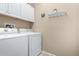 Bright laundry room with washer, dryer, and overhead cabinets at 21816 N 261St Ave, Buckeye, AZ 85396