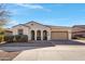 One-story home with tan exterior, two-car garage, and landscaped front yard at 22085 E Rosa Rd, Queen Creek, AZ 85142