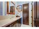 Stylish bathroom with dark wood cabinets and blue and white striped wallpaper at 27931 N Montana Dr, Rio Verde, AZ 85263