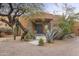 Front entrance with a gray door, stone pillars, and desert landscaping at 30600 N Pima Rd # 63, Scottsdale, AZ 85266