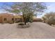 Landscaped front yard with a circular driveway and a large tree at 30600 N Pima Rd # 63, Scottsdale, AZ 85266