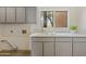 Functional laundry room with gray cabinets and window at 30600 N Pima Rd # 63, Scottsdale, AZ 85266