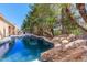 Inviting swimming pool surrounded by rocks and lush landscaping at 3731 E Fruitvale Ave, Gilbert, AZ 85297