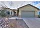 Tan house with a gray garage door and stone accents at 4347 W White Horse Blvd, Eloy, AZ 85131