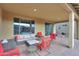 Spacious covered patio with wicker furniture and red accent chairs at 4347 W White Horse Blvd, Eloy, AZ 85131