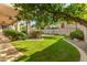 Landscaped backyard featuring a large grassy area and covered patio at 4543 E Molly Ln, Cave Creek, AZ 85331