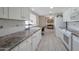 Galley kitchen with white cabinets, granite countertops, and view to dining area at 4902 E Flossmoor Ave, Mesa, AZ 85206