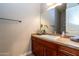 Well-lit bathroom with wood cabinets, single sink vanity, and a large mirror at 5626 E Sleepy Ranch Rd, Cave Creek, AZ 85331