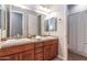 Bathroom featuring double sinks, wood cabinets and a large mirror at 5626 E Sleepy Ranch Rd, Cave Creek, AZ 85331