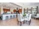 Open-concept dining area with a glass table, white chairs, and built-in shelving, adjacent to a modern kitchen at 5626 E Sleepy Ranch Rd, Cave Creek, AZ 85331