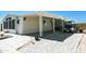 Tan mobile home with covered porch and paved driveway at 5735 E Mcdowell Rd # 38, Mesa, AZ 85215